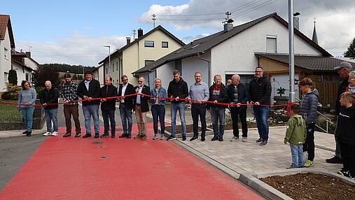 Foto zum Thema "wie wird man Bürgermeister": Zu sehen ist Joachim Weschbach, er schneidet ein rotes Band durch. Eine neue Straße wird eingeweiht.