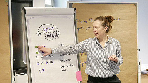Das Foto zeigt Lisa Dürer, Geschäftsführerin der Akademie für Ehrenamtlichkeit. Sie erklärt etwas am Flipchart.