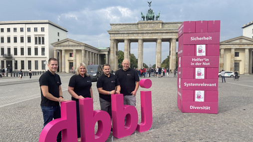 Mitglieder der dbb jugend stehen in Berlin vorm Brandenburger Tor und machen auf den Personalmangel im öffentlichen Dienst aufmerksam. 