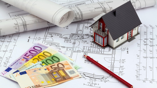 Bauzinsen - Für viele einmal im Leben an architect's blueprint with euro money. symbolic photo for funding and planning of a new home.