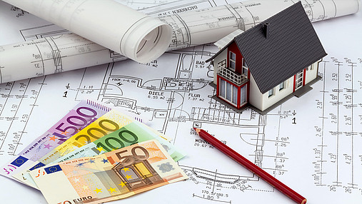 an architect's blueprint with euro money. symbolic photo for funding and planning of a new home.