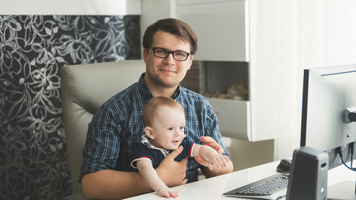 Symbolfoto zum Thema "Fachkräftemangel im öffentlichen Dienst": Zu sehen ist ein Vater mit seinem Sohn im Büro.