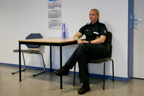 JVA Hahnöfersand - Aufsicht Foto zum Thema "JVA Hahnöfersand": Zu sehen ist Justizvollzugsbeamtin Dammann während der Aufsicht im Besucherraum.