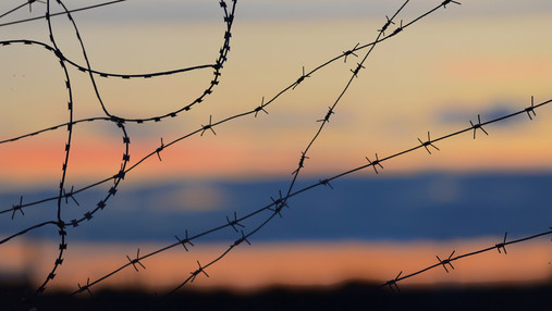 Histadrut - wie der Krieg das Leben eines Gewerkschafters verändert Das Foto zeigt Stacheldraht vor einem Abendhimmel.