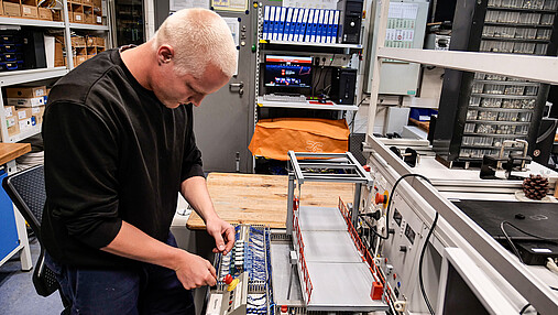 Foto zum Thema "Ausbildung Elektroniker": Zu sehen ist Ben Morgenstern, der am Modell einer Klappbrücke arbeitet.