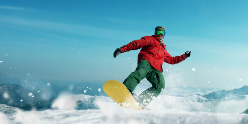 Ein Snowboardfahrer in Aktion auf der Schneepiste.
