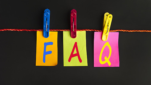 Foto zum Thema "FAQ TVöD, TV-L, TV-H": Zu sehen ist eine Wäscheleine, an der mit großen Klammern drei Papiere befestigt sind. Auf dem ersten steht "F", auf dem zweiten "A" und auf dem dritten "Q".