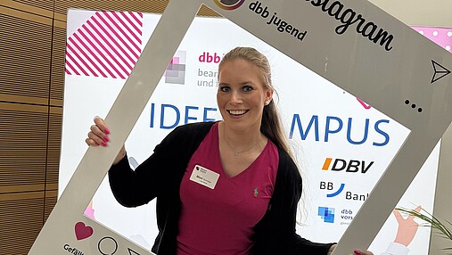 Foto zum Thema "Wie wird man Social-Media-Managerin": Zu sehen ist Maxi Schröder mit einem Insta-Frame der dbb jugend.