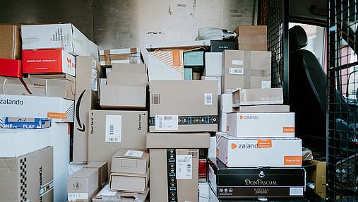 Foto zum Thema Probleme in der Paketzustellung: Zu sehen ist der Innenraum eines Zustellfahrzeugs, in dem sich sehr viele Pakete befinden.