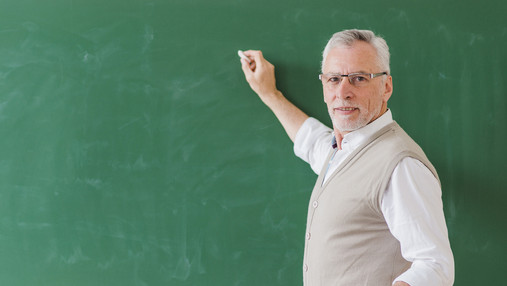 Remonstrationspflicht - Lehrer schildert Beispiel für Remonstration Foto zum Thema Remonstrationspflicht: Zu sehen ist ein Lehrer, der ein Stück Kreide in der Hand hält und an der Tafel steht.