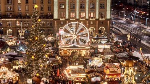 Foto zum Thema "Dresdener Striezelmarkt": Zu sehen ist eine Luftaufnahme des Marktes, die Lichter leuchten in der Dunkelheit. In der Mitte ist das Riesenrad zu sehen. 