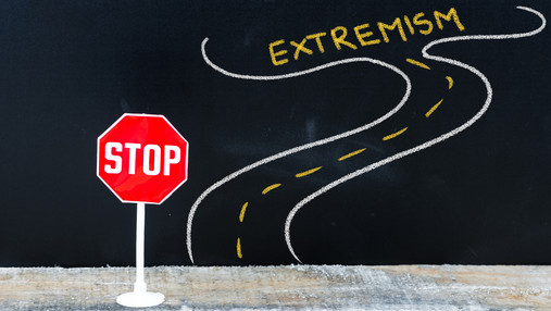 Foto zum Thema FES Mitte-Studie: Zu sehen ist ein Stoppschild an einer Straße, an deren Ende ein Extremismus-Schriftzug erscheint.