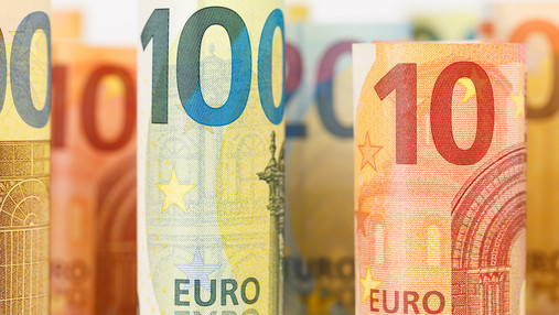 Foto zum Thema "Beamtenkredite": Zu sehen sind zusammengerollte Banknoten, 100 Euro- sowie Zehn-Euro-Scheine.