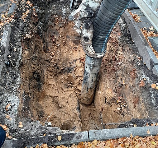 Foto zum Thema "kommunale Baumpflege": Zu sehen ist eine Leitung in einem Erdloch, in dem eine Neupflanzung erfolgen soll.